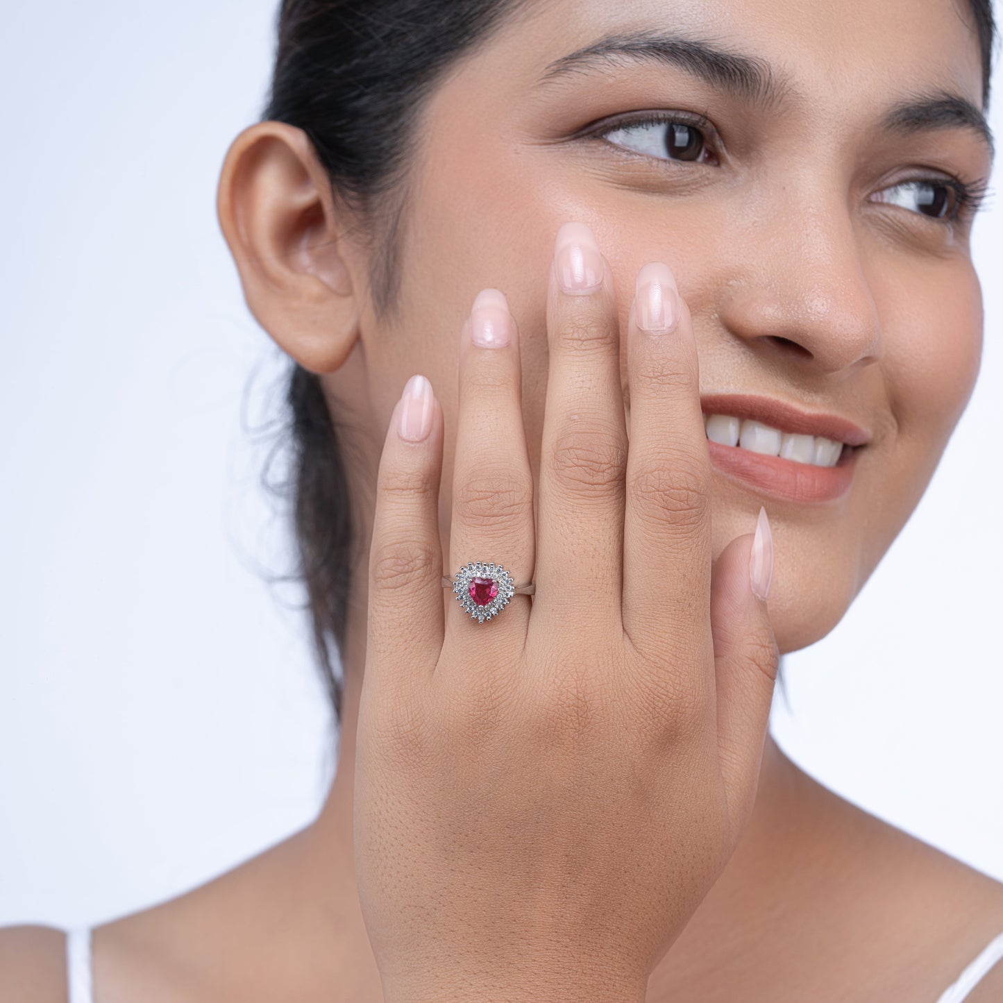 Elegant silver ring with pink heart center stone and crystal surround on a model's hand