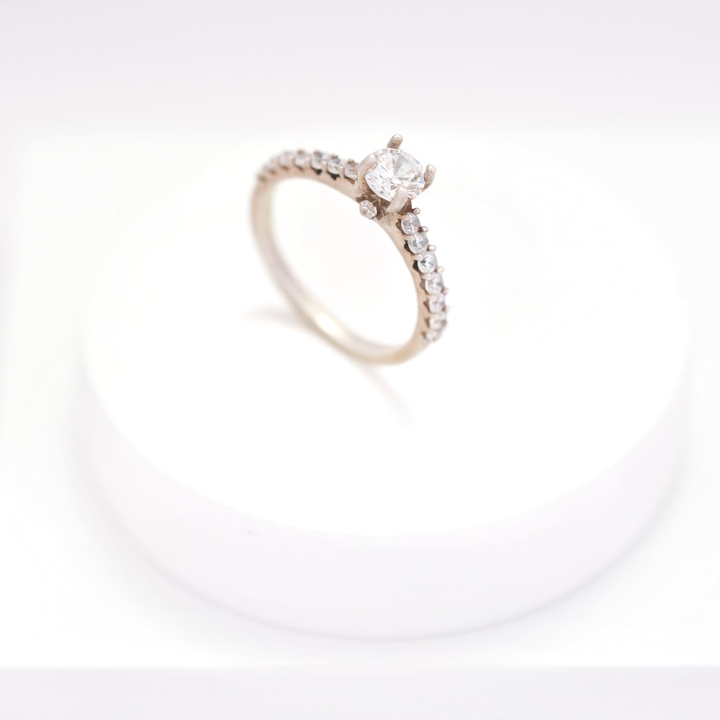 Elegant silver ring for women with a sleek, minimalist design, displayed on a white pedestal