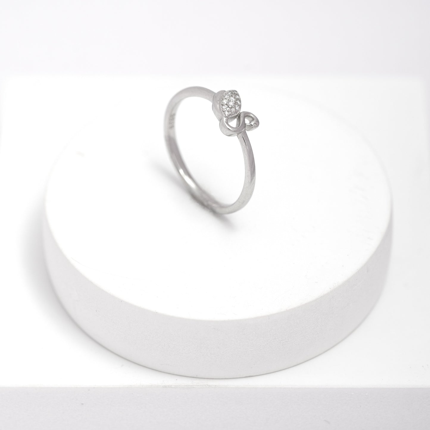 Silver swan ring on a white stand