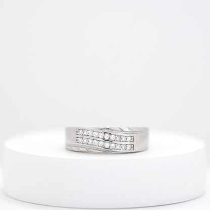 Silver ring with embedded diamonds on a white stand