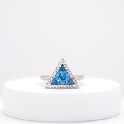 front view of sterling silver ring for woman with a blue stone on a white stand 